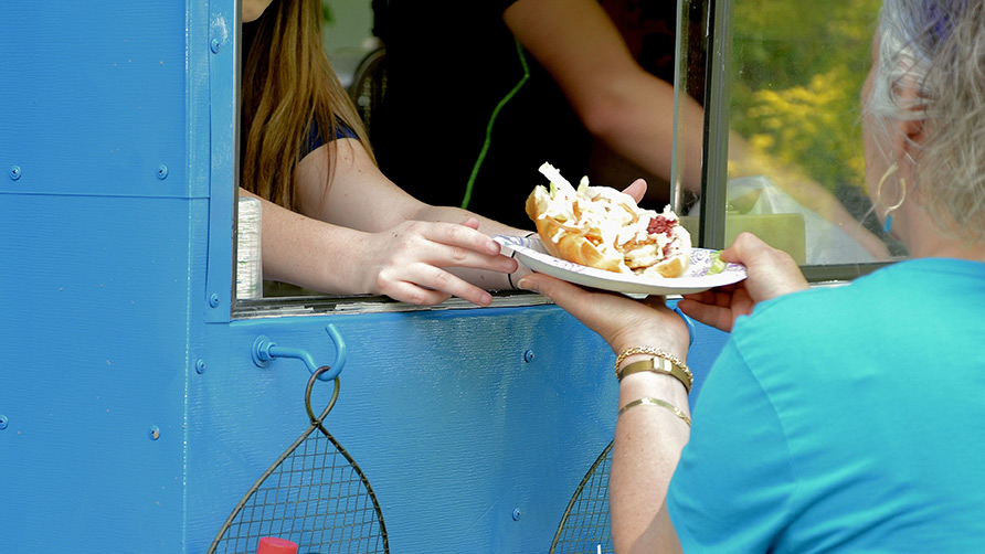 making-a-purchase-from-a-food-truck-at-an-outdoor-2022-11-14-03-40-25-utc